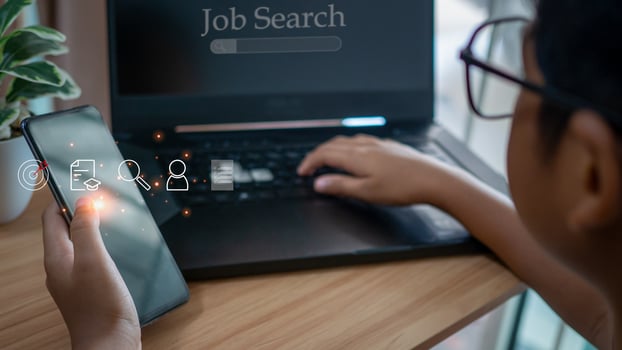 Human holding  smart phone and using computer laptop to job search on online internet. applying for a job concept. photo
