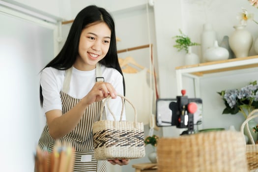 Close up young asian businesswoman fashion blogger showing woven basket products with smiling. photo