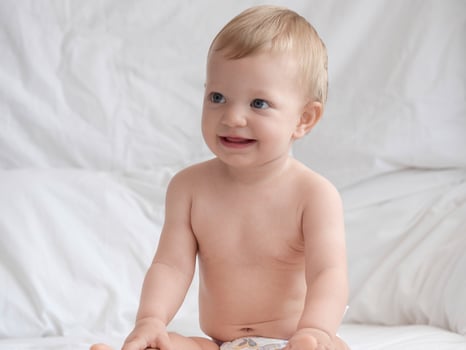 Cute Baby Sitting and Smiling on The Bed photo