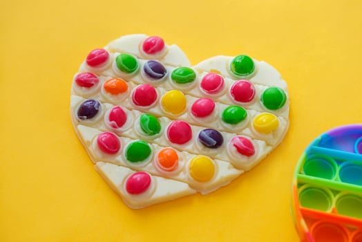 Use the popular pop it toy as a chocolate mold. White chocolate and colorful candies and popit silicone toy. DIY concept. Step-by-step photo instructions. Step 10.