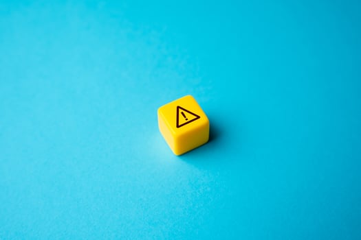 Warning sign on yellow block. Stress, problems. Something wrong. Danger or problem ahead. Careful proceed with caution. Workplace safety. Potential risks. Stress and mental health photo