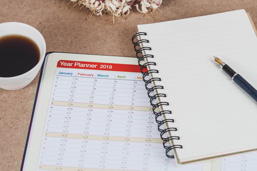 personal organizer or planner with fountain pen and hot coffee on wood table. photo