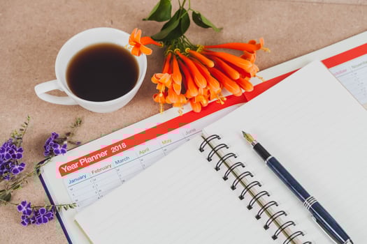 personal organizer or planner with fountain pen and hot coffee on wood table. photo