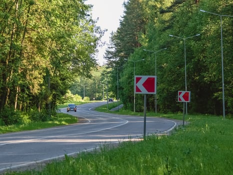 Car rides on winding highway in an summer forest photo