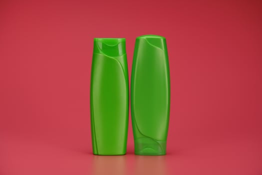 Two Green Blank Label Shampoo Bottle or Shower Gel on Pink Background photo