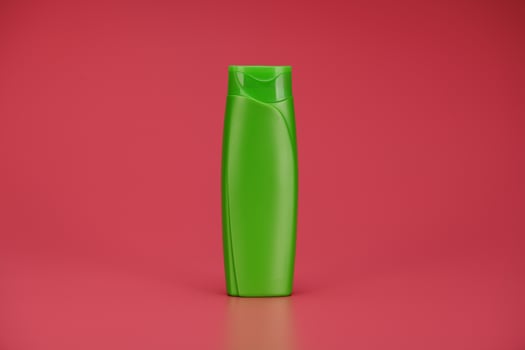 Green Blank Label Shampoo Bottle or Shower Gel on Pink Background photo