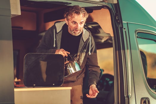 Men with Water Kettle Inside Camper Van photo