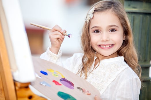 Little blonde girl painting outdoors photo