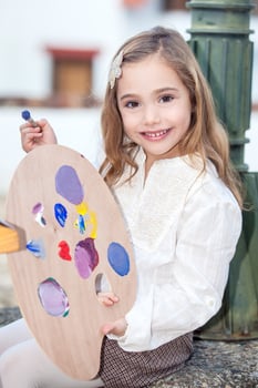 Little blonde girl painting outdoors photo