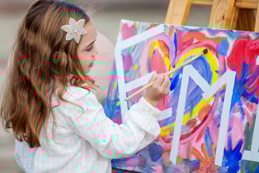 Little blonde girl painting outdoors photo
