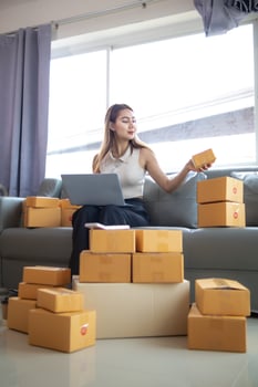 small sme entrepreneur is packing products into parcel boxes in preparation for transporting them to freight forwarder to deliver to customers with incoming orders. Concept Ecommerce Team online sales photo