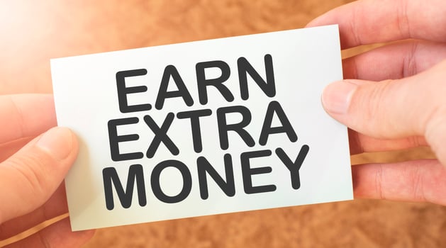 EARN EXTRA MONEY word inscription on white card paper sheet in hands of a businessman. recap concept. red and white paper photo