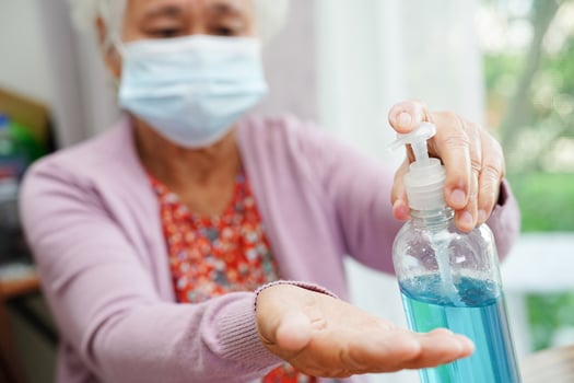 Asian senior woman press blue alcohol sanitizer gel for washing hand protect infection coronavirus. photo