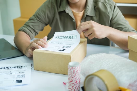 Young entrepreneur packing online order product for shipping. photo