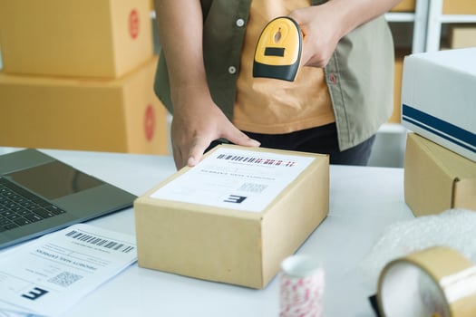 Young entrepreneur scanning online order box. photo