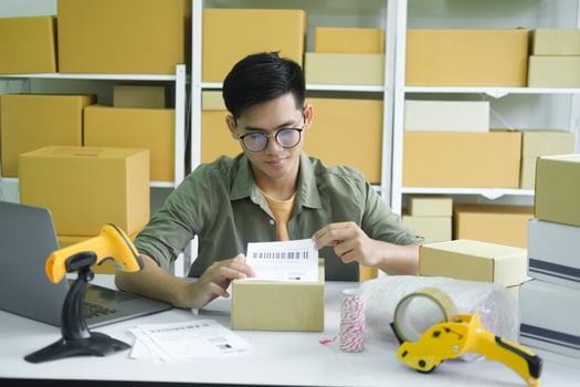 Young entrepreneur packing online order product for shipping. photo