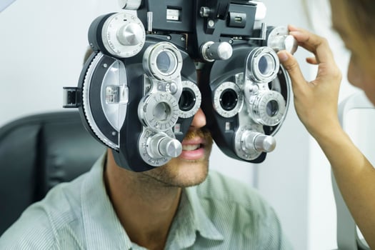 Man having eye test using phoropter. photo