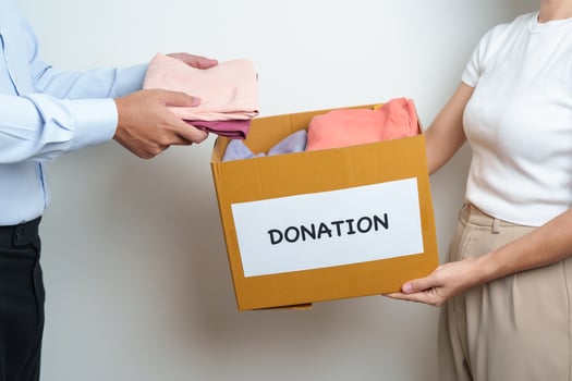Donation, Charity, Volunteer, Giving and Delivery Concept. People donate Clothes into Donation box at home or office for support and help poor, refugee and homeless people. Copy space for text photo