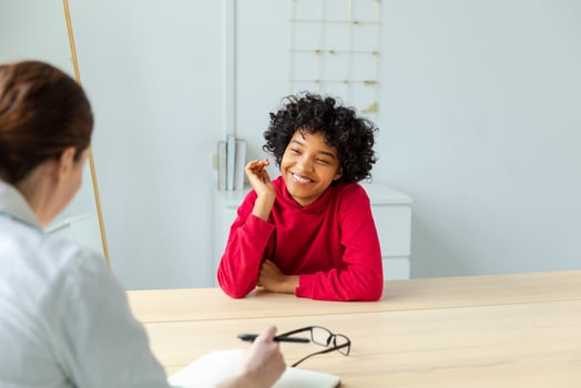 Young african american woman patient and female doctor in doctor office. Girl patient and doctor have consultation in hospital room. Medicine healthcare medical checkup concept. Visit to doctor. photo
