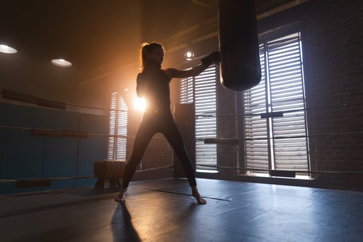Women self defense girl power. Strong woman fighter training punches on boxing ring. Healthy strong girl punching boxing bag. Training day in boxing gym. Strength fit body workout training. photo