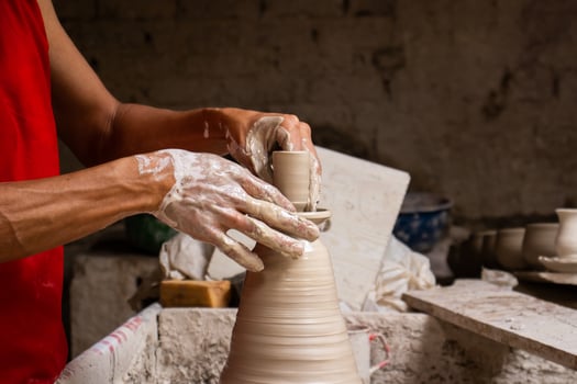 Man making ceramic articles on the potters wheel in a traditional factory in the city of Raquira located in the department of Cundinamarca in Colombia photo