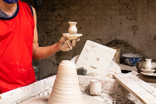 Man making ceramic articles on the potters wheel in a traditional factory in the city of Raquira located in the department of Cundinamarca in Colombia photo