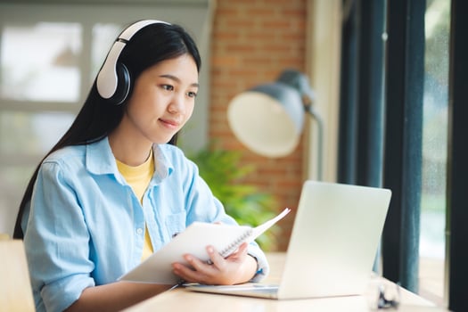 Young asian learning online using laptop stting at table. photo
