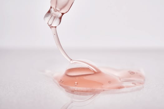 Pipette with a viscous pink cosmetic close-up. photo