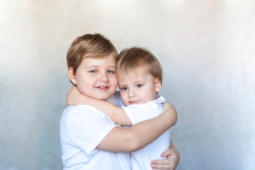 Boys-brothers in an embrace. Happy boys hug each other. Overjoyed, the best friends embrace. photo