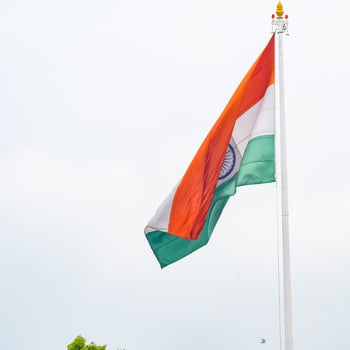 India flag flying high at Connaught Place with pride in blue sky, India flag fluttering, Indian Flag on Independence Day and Republic Day of India, tilt up shot, Waving Indian flag, Har Ghar Tiranga photo