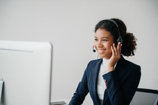 Serious call center operator in wireless headset talking with customer, woman in headphones with microphone consulting client on phone in customer support service in office photo