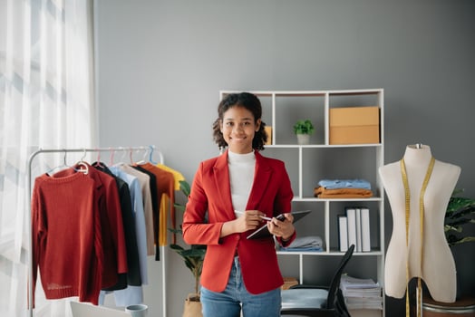 Diverse female fashion designers at work with tailor centimeters on necks and holds tablet and smartphone. independent creative design business. photo