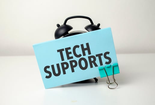 tech supports is written in a blue sticker near a black alarm clock photo