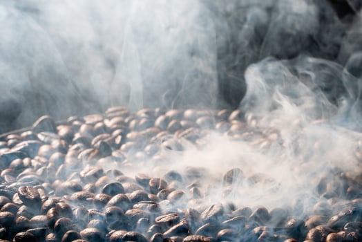Coffee beans roasting with smoke,  selective focus, and soft focus. photo