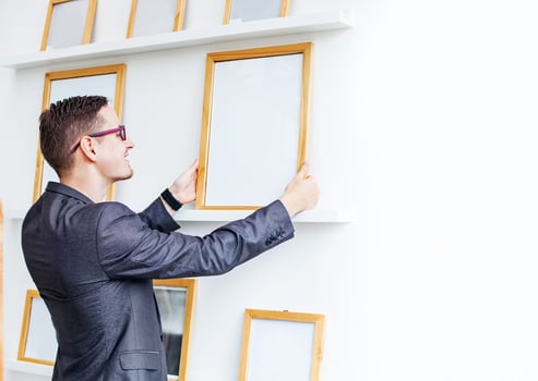 young man hanging a blank poster in exhibition hall photo