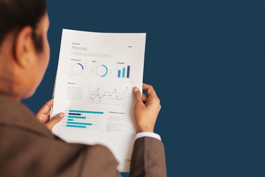 a woman in a business suit holding a piece of paper with graphs and diagrams photo