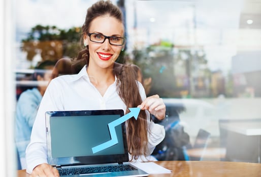 a woman in glasses holding a laptop with an arrow pointing up photo