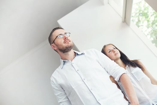 a man and woman standing in front of a window photo