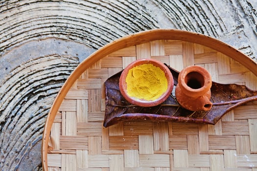 a wooden tray with two small bowls and a yellow liquid photo