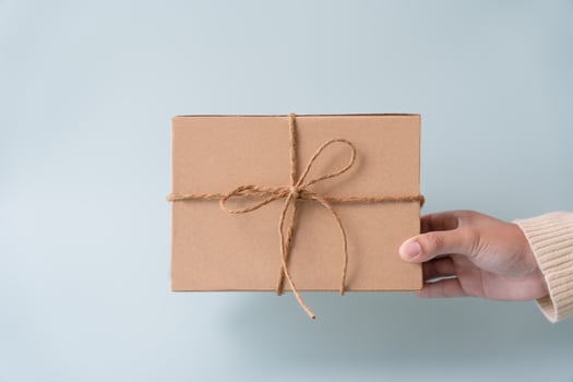 Woman carrying gift paper box tie cute ribbon for special occasion. Delivery sending present to someone special to thank or surprise. photo