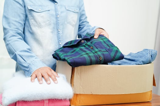 Clothes donations in cardboard box for volunteer. photo