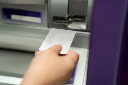 Close up of female hand using credit To withdrawing Money from atm Machine. photo