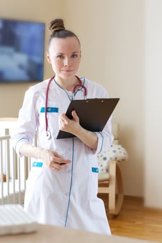 A young smiling doctor dressed in a white professional uniform photo