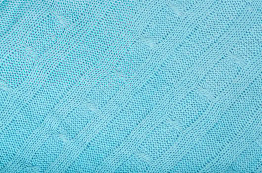 Blue coloured knitted surface. Closeup photo