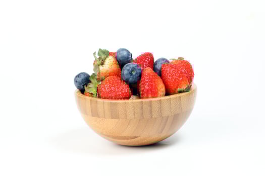 Strawberry blueberry in wooden bowl on white background photo