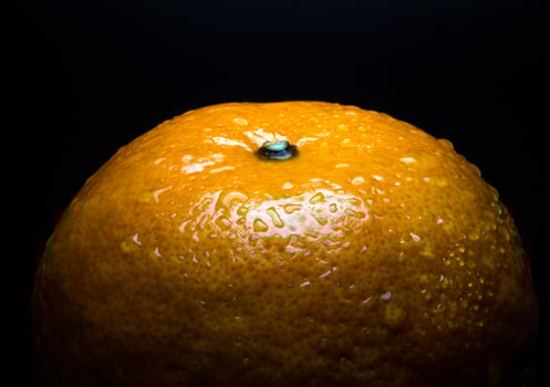 Water droplet on glossy surface of freshness orange on black background photo