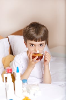 Sick child is drinking tea photo