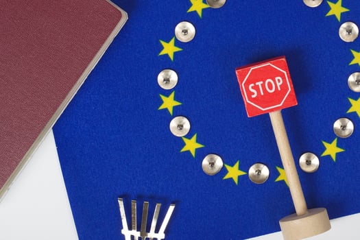 Agricultural tools,a card with access forbidden,pins,and a passport on an European flag.Closeup photo