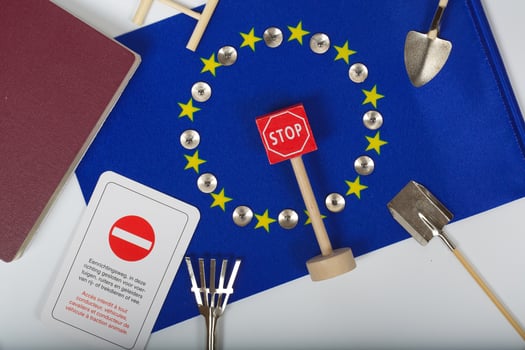 Agricultural tools,a card with access forbidden,pins,and a passport on an European flag.Closeup photo