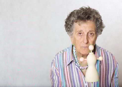 Old woman with mini woodenmade mannequin photo